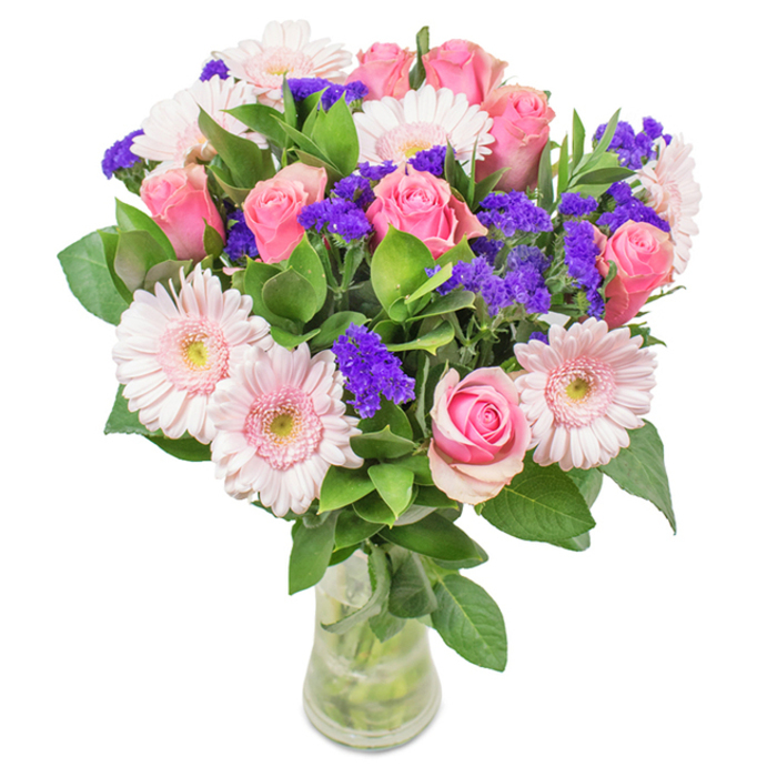 Elegantly composed and set in a clear glass vase against a pure white backdrop, this lush bouquet embodies the artistry of White City florists. The centerpiece boasts approximately 7 to 9 pink roses, ranging from tightly closed buds to pieces just beginning to reveal their luxurious spiral petals. Each rose offers a rich, romantic hue, subtly varying from soft blush to deeper pink. Interwoven through the arrangement are about 5 to 7 pale pink gerbera daisies, their large, round flower heads and softly radiating petals lending a gentle, welcoming feel. Deep purple statice clusters provide textural interest and splashes of vibrant colour, contrasting beautifully with the pastel palette. Lush dark green foliage forms a bountiful base, enhancing the sense of abundance and evoking the gardens that flourish throughout White City. Visible, water-filled stems in a transparent vase reflect light, conveying freshness and the promise of longevity. Well-suited for birthdays, anniversaries or as a thoughtful gift delivered across White City and Shepherd's Bush, this bouquet symbolises joy, celebration and affection with unmistakable local character.